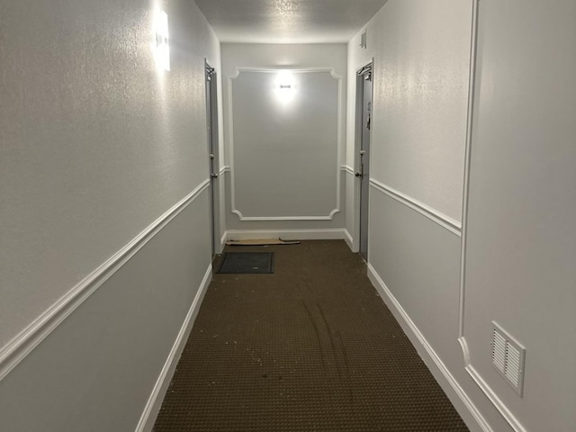 corridor with dark colored carpet