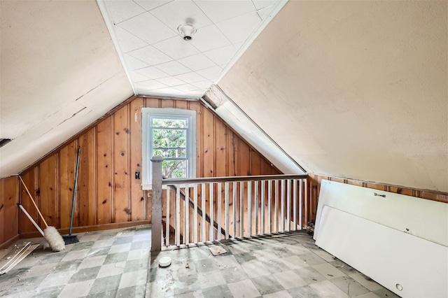 additional living space with wooden walls and vaulted ceiling