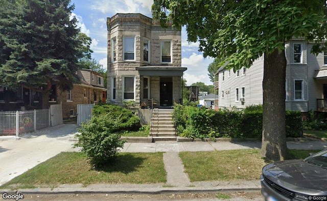 view of front facade with fence and stone siding