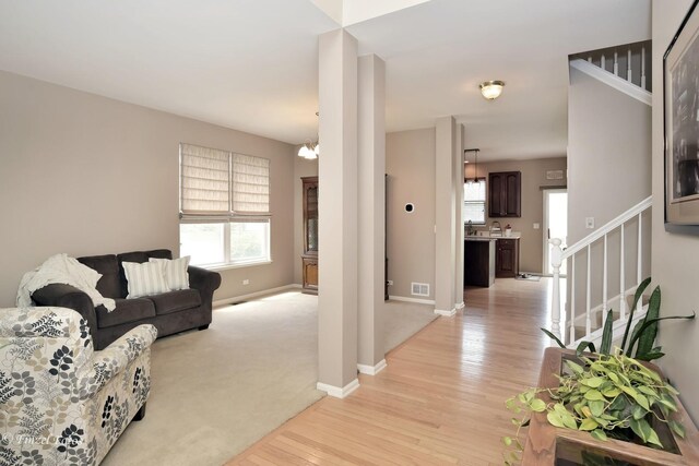 living room with a notable chandelier and light hardwood / wood-style flooring