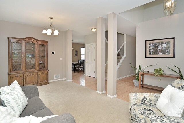 living room with an inviting chandelier and light hardwood / wood-style floors