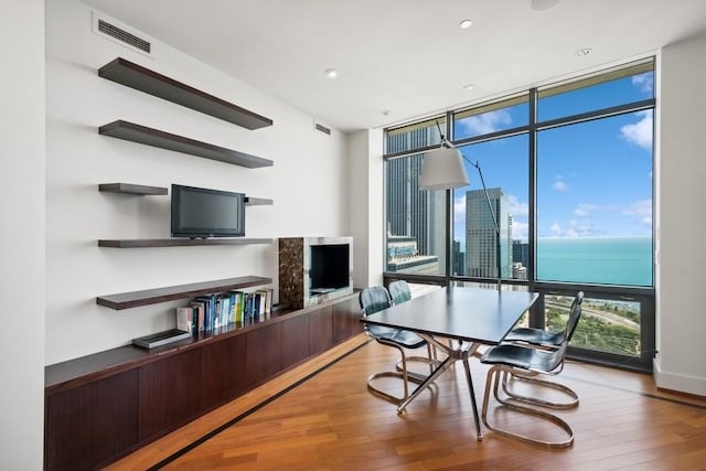 home office with wood-type flooring and floor to ceiling windows