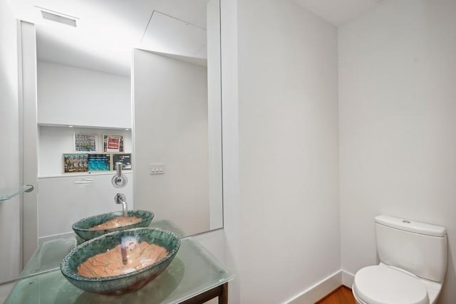 bathroom with hardwood / wood-style floors, vanity, and toilet