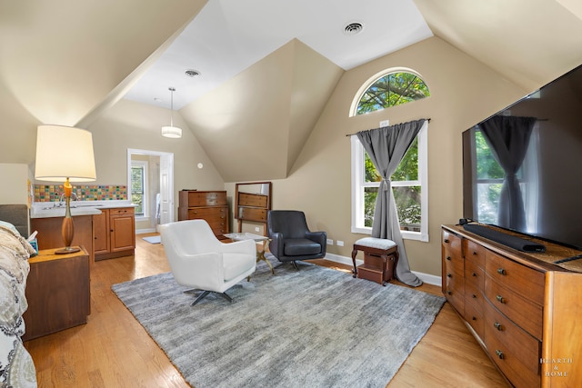 living room featuring lofted ceiling and light hardwood / wood-style floors