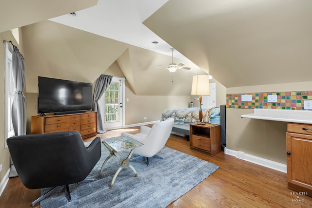 living room with lofted ceiling, hardwood / wood-style floors, and ceiling fan