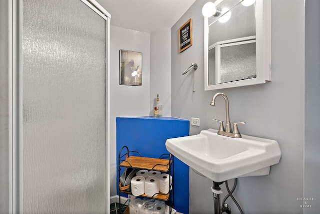 bathroom featuring an enclosed shower and sink