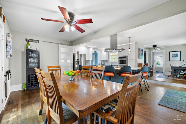 dining room featuring a wealth of natural light, ceiling fan, and dark hardwood / wood-style floors