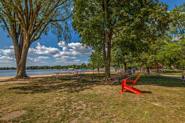 surrounding community featuring a water view and a lawn