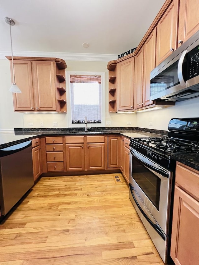 kitchen featuring sink, light hardwood / wood-style flooring, ornamental molding, appliances with stainless steel finishes, and decorative light fixtures