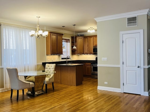 kitchen with stainless steel appliances, crown molding, decorative light fixtures, a chandelier, and hardwood / wood-style floors