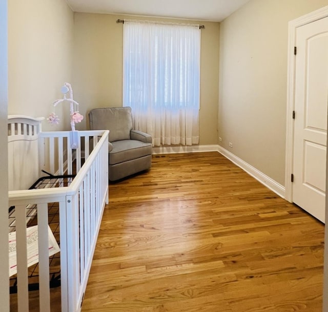 bedroom featuring a crib and light wood-type flooring