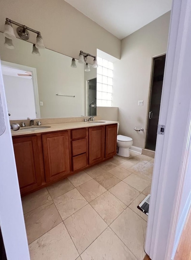 bathroom featuring vanity, toilet, and walk in shower