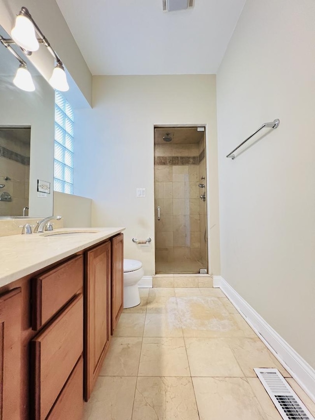 bathroom featuring tile patterned floors, toilet, vanity, and walk in shower