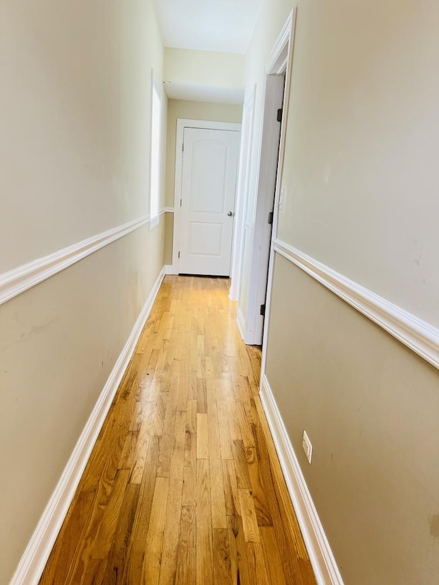 hallway with light hardwood / wood-style floors