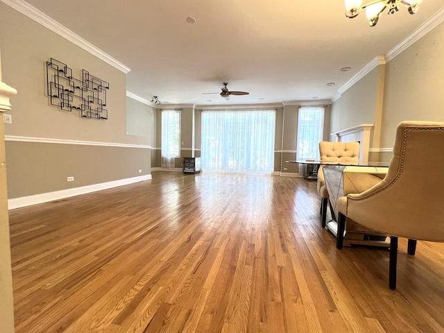 sitting room with hardwood / wood-style floors, ceiling fan with notable chandelier, and ornamental molding