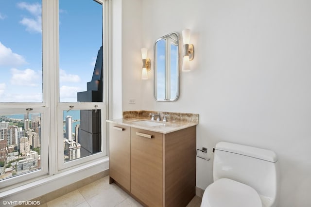 bathroom with toilet, tile patterned flooring, and vanity