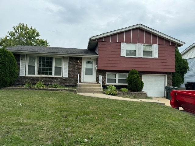 split level home featuring a garage and a front lawn