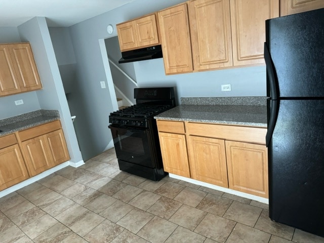 kitchen featuring light brown cabinetry, exhaust hood, black appliances, and light tile patterned floors