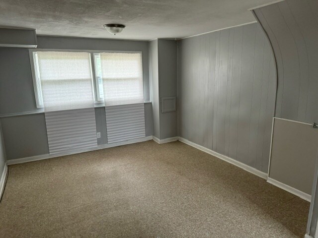 carpeted empty room with a textured ceiling