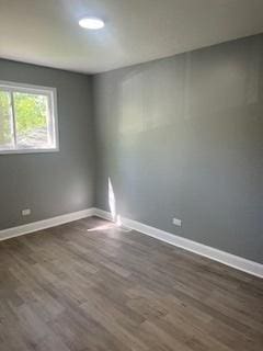 unfurnished room with dark hardwood / wood-style flooring