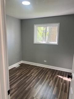 spare room featuring dark wood-type flooring