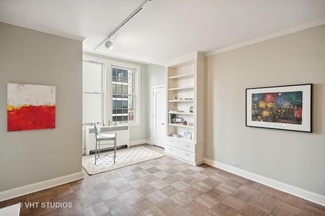 unfurnished bedroom with baseboards, track lighting, crown molding, and radiator