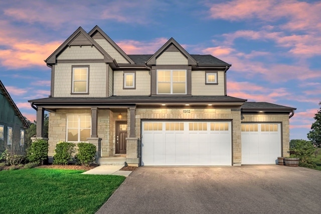 craftsman house featuring a garage and a yard