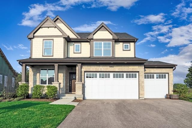 view of front of property featuring aphalt driveway, a garage, and a front yard