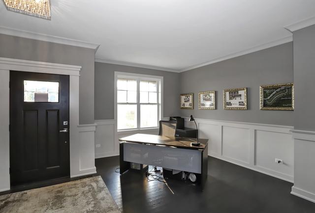 office space featuring a wainscoted wall, dark wood finished floors, crown molding, and a decorative wall