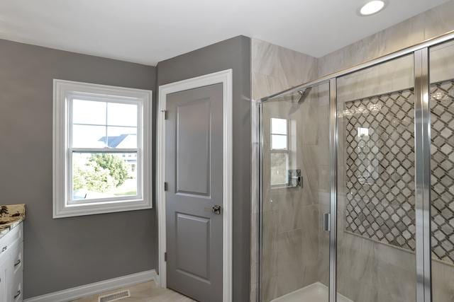 full bath with visible vents, a shower stall, vanity, and baseboards