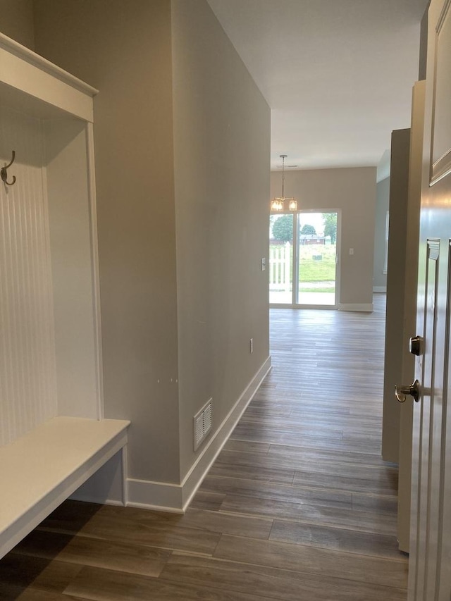 hallway featuring dark hardwood / wood-style flooring and a chandelier