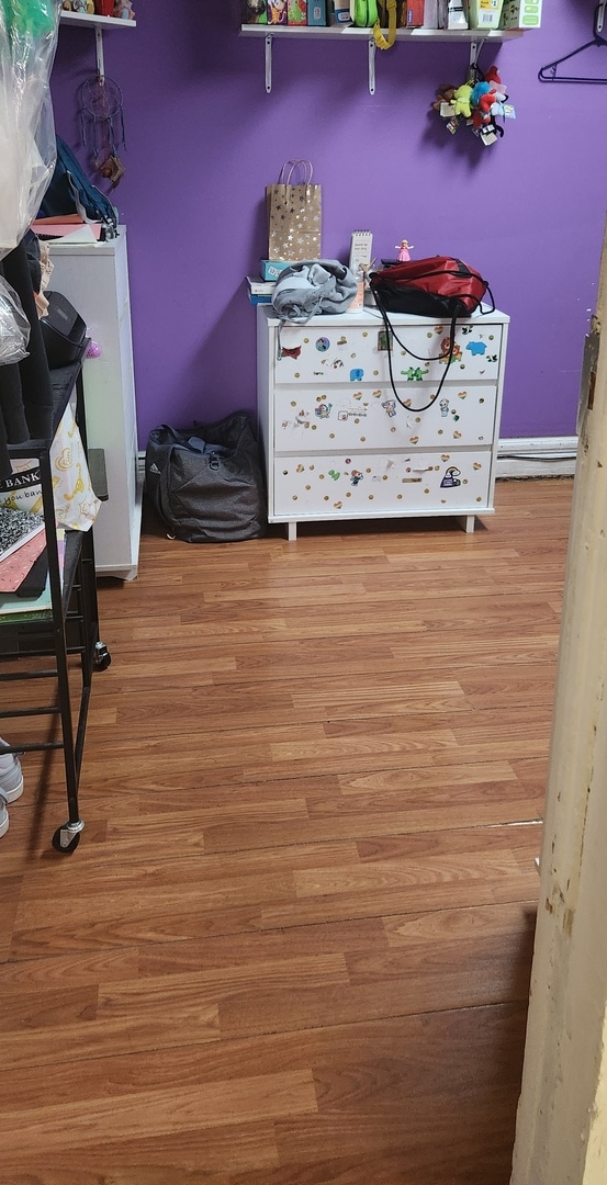 bedroom with light wood-type flooring and refrigerator