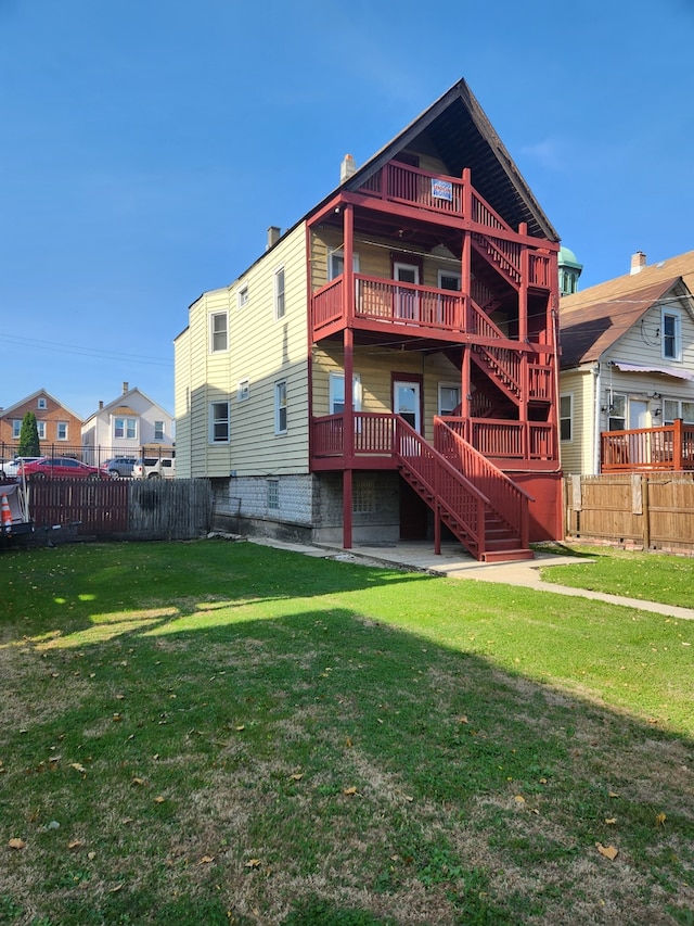 rear view of property with a yard and a balcony