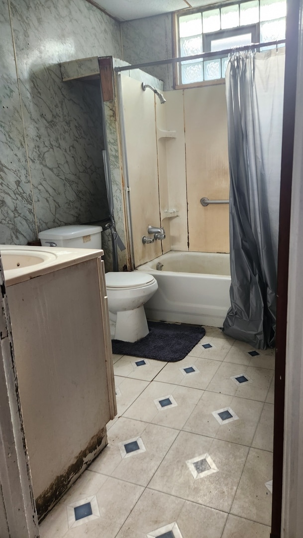 full bathroom with tile patterned floors, vanity, toilet, and shower / bath combo with shower curtain