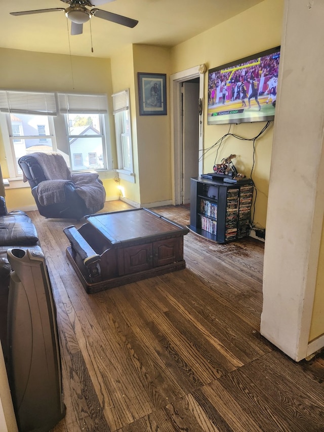 living room with ceiling fan and dark wood-type flooring