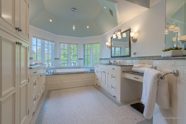 bathroom with tile patterned floors, vanity, and a tub to relax in