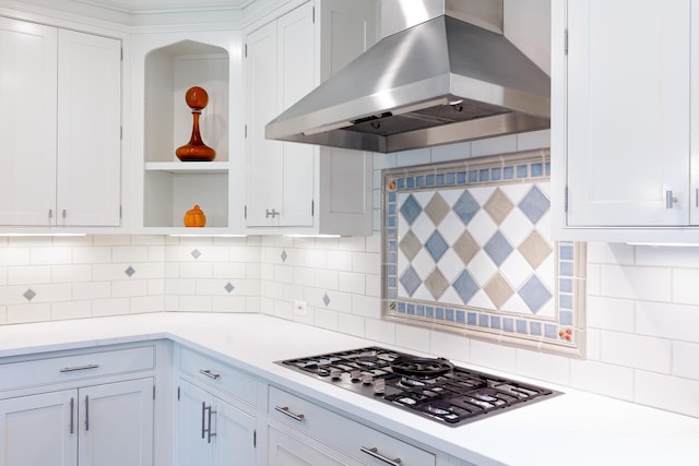 kitchen with wall chimney exhaust hood, white cabinetry, backsplash, and stainless steel gas cooktop