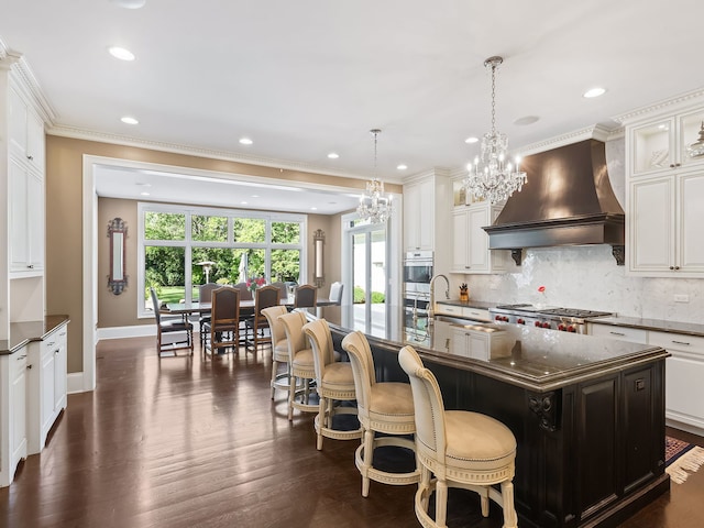 kitchen with tasteful backsplash, dark wood-style flooring, custom range hood, and a sink