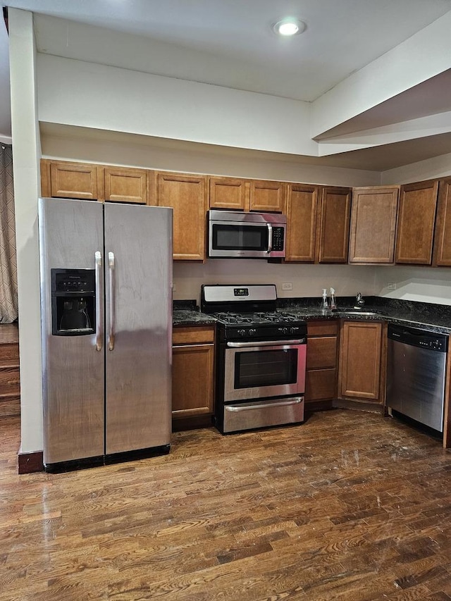 kitchen with appliances with stainless steel finishes and dark hardwood / wood-style floors