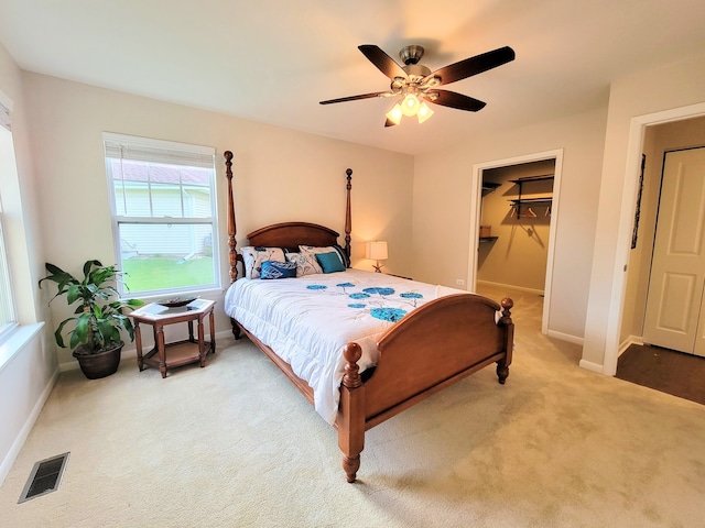 bedroom with carpet floors, a walk in closet, ceiling fan, and a closet