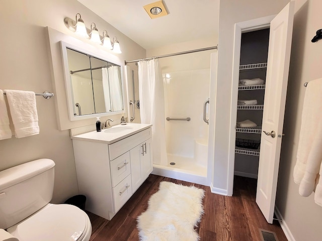 bathroom featuring curtained shower, toilet, vanity, and hardwood / wood-style floors