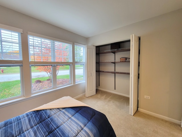 unfurnished bedroom with light carpet, multiple windows, and a closet