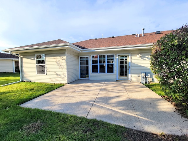 rear view of property featuring a patio and a lawn