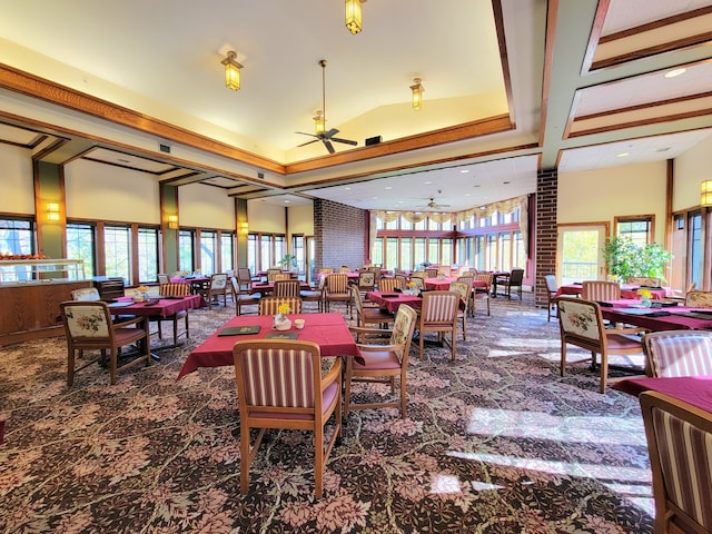 carpeted dining room featuring a high ceiling, brick wall, and ceiling fan