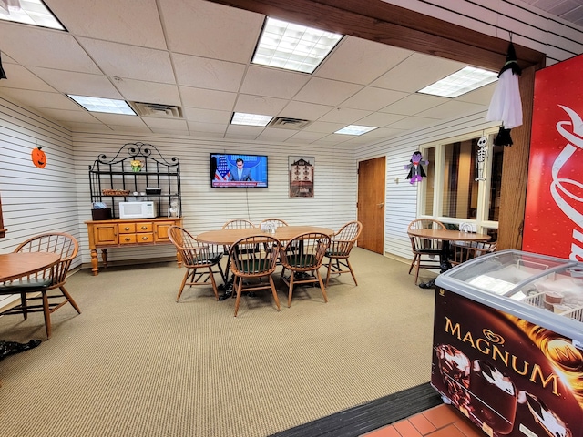 dining area with carpet flooring and a drop ceiling