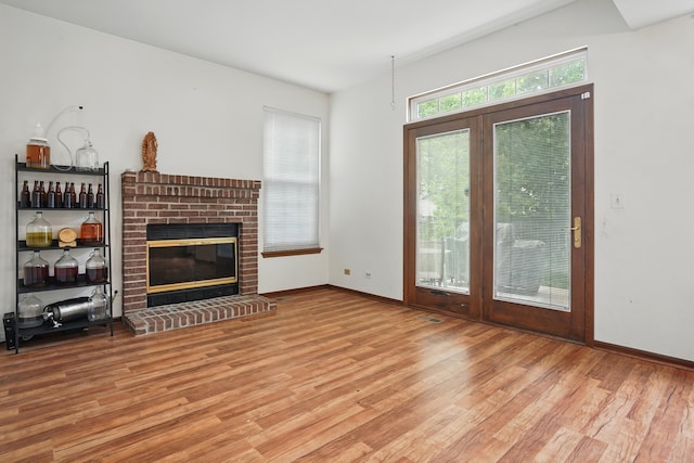 1406 Trescott St, Mundelein, IL 60060 - unfurnished living room featuring wood finished floors, a brick fireplace, and baseboards