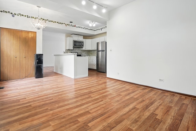 1406 Trescott St, Mundelein, IL 60060 - kitchen featuring appliances with stainless steel finishes, open floor plan, track lighting, light wood-style floors, and white cabinetry