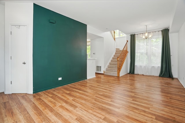 1406 Trescott St, Mundelein, IL 60060 - unfurnished living room featuring a chandelier, stairway, light wood-type flooring, and baseboards