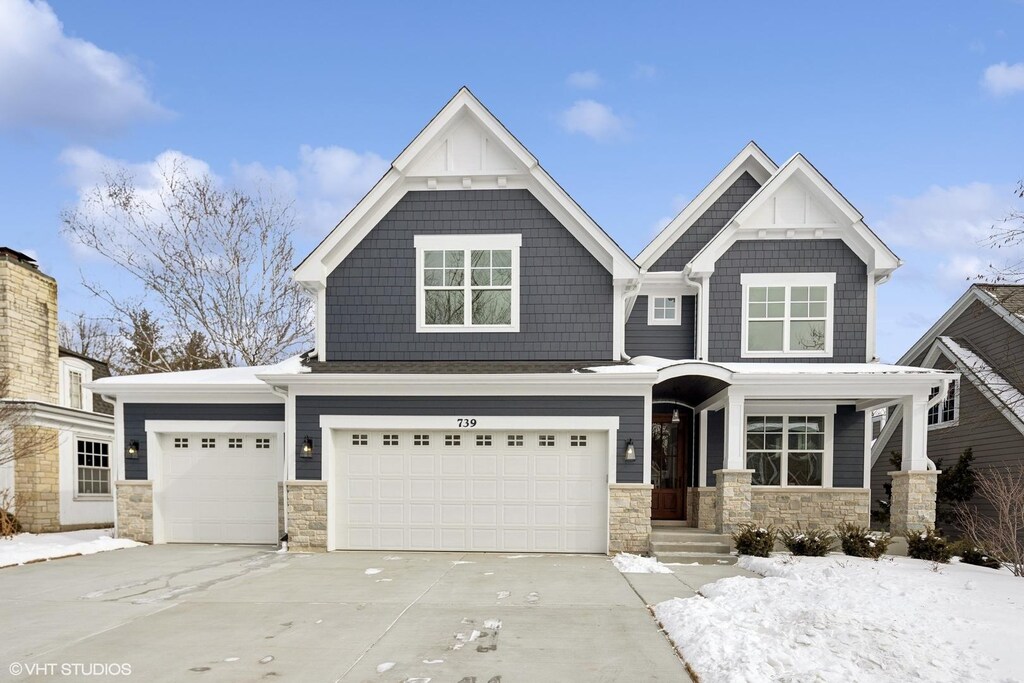 craftsman inspired home featuring a garage and a front lawn