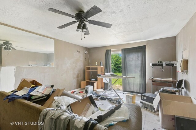 tiled living room with a textured ceiling and ceiling fan